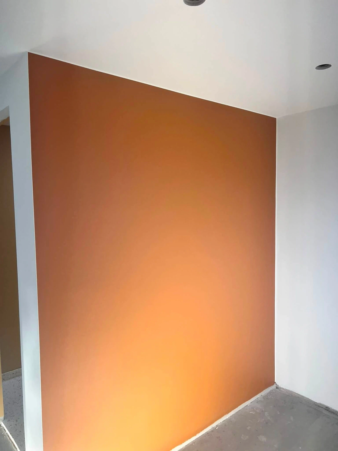 Vægmaling i varm orange farve i moderne boligindretning.