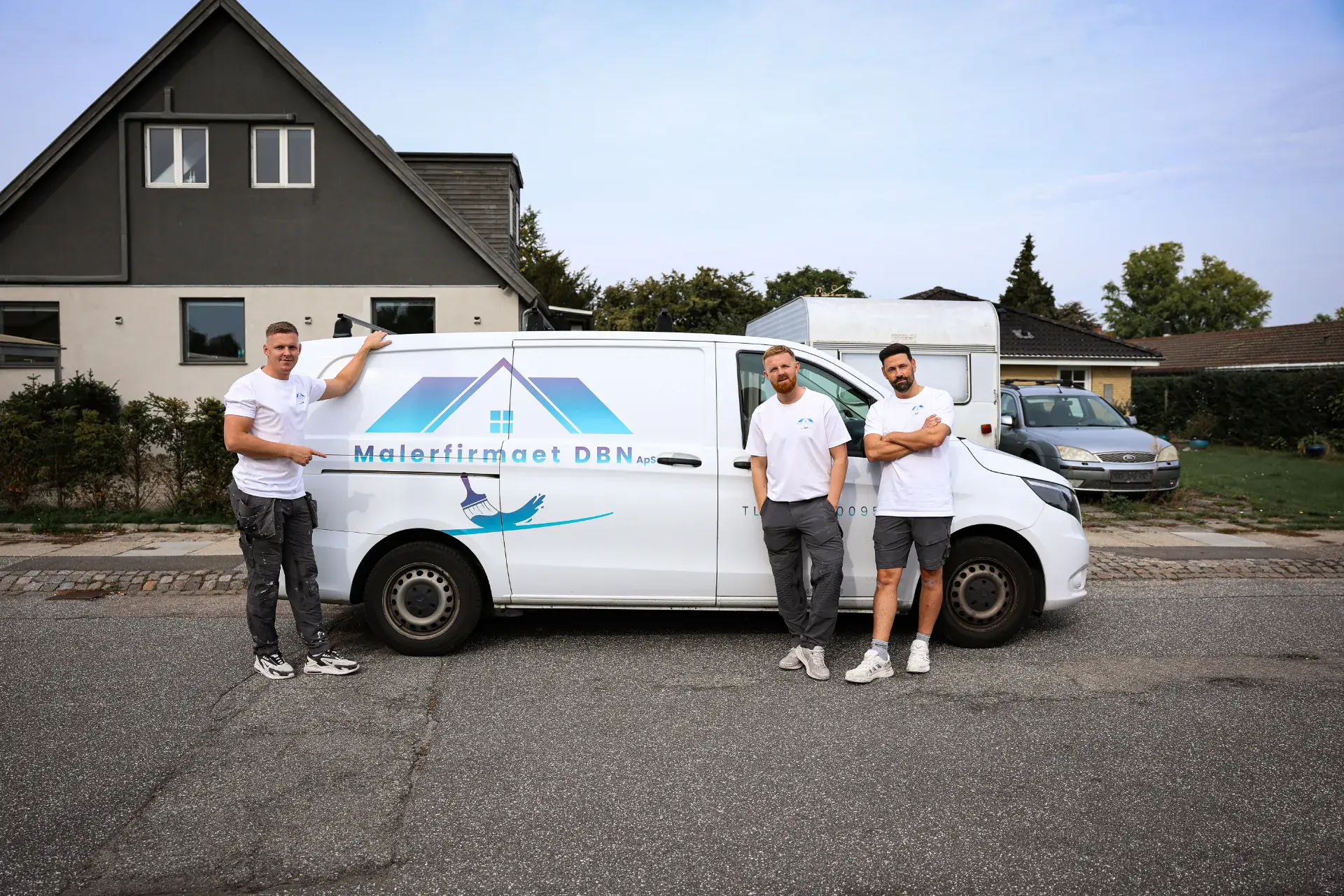 Malerfirmaet DBN ApS team står foran firmabil i boligområde.