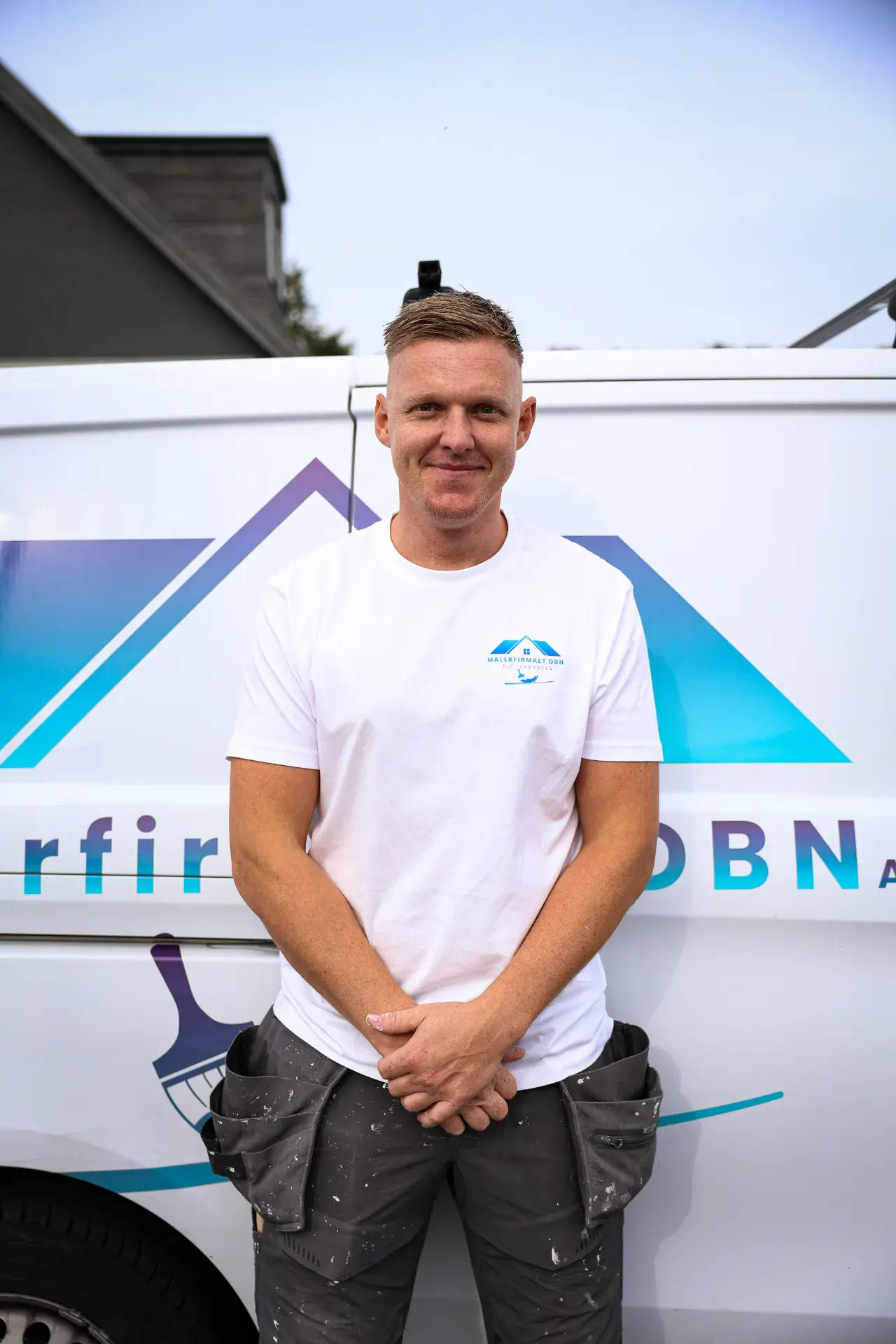 Malerfirmaet DBN ApS medarbejder foran firmabil.
